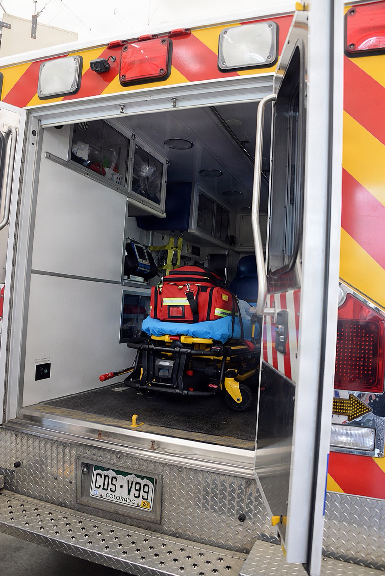 An ambulance crew works at the back of a unit.
